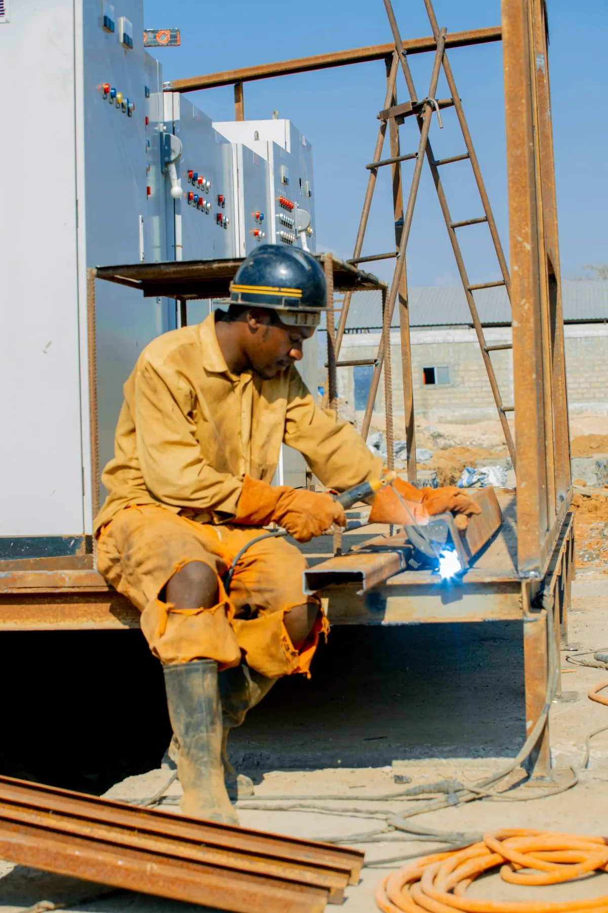 Welder fabricating a steel beam on site