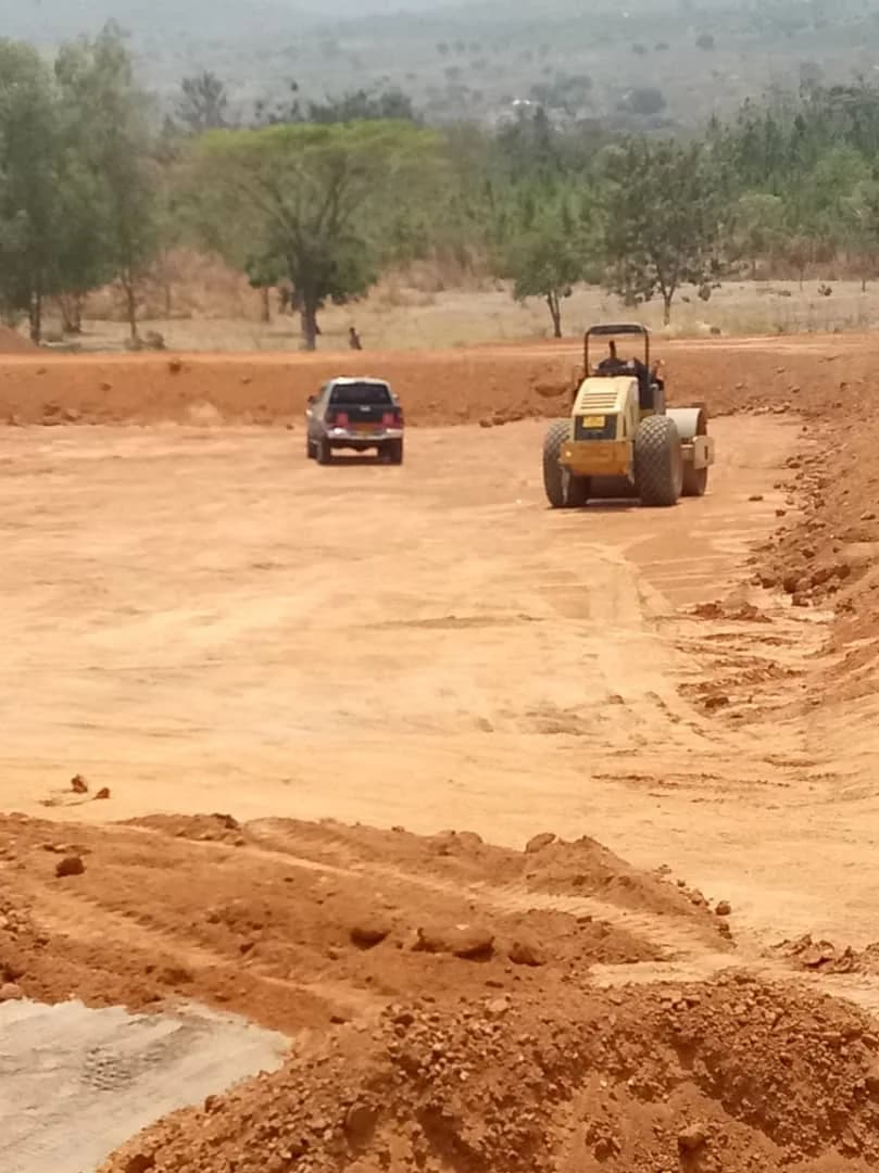 Grader shaping the TSF embankment above the exposed clay liner