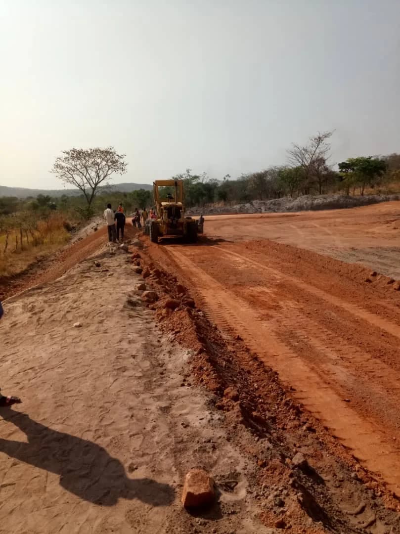 Grader shaping an access road along the ridge