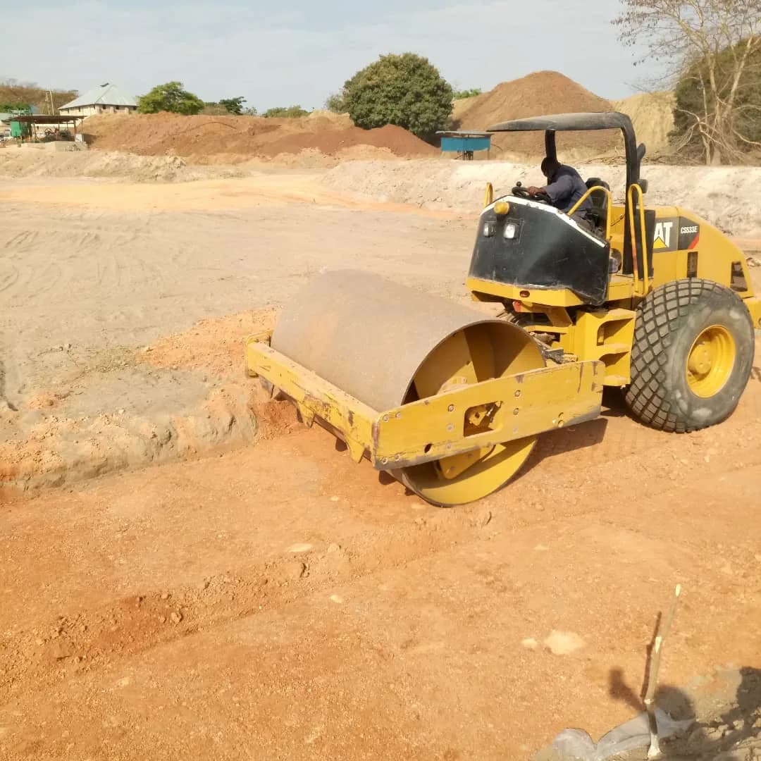 Roller compacting beside the clay-lined TSF basin