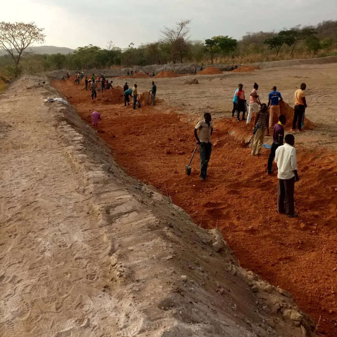 Workers levelling the excavated TSF basin by hand