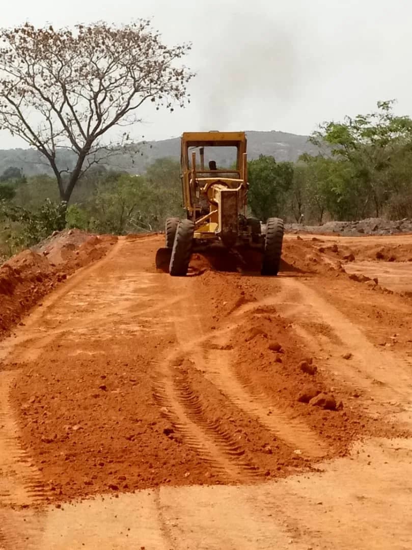 Grader shaping the red earth access road