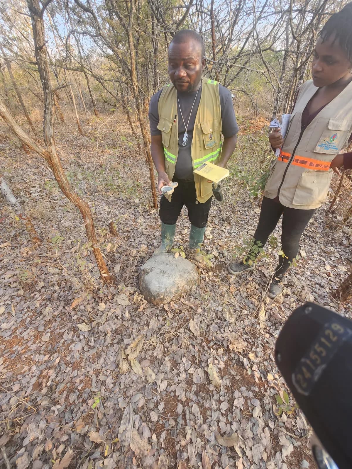 Geologist taking a compass reading on a marked rock sample