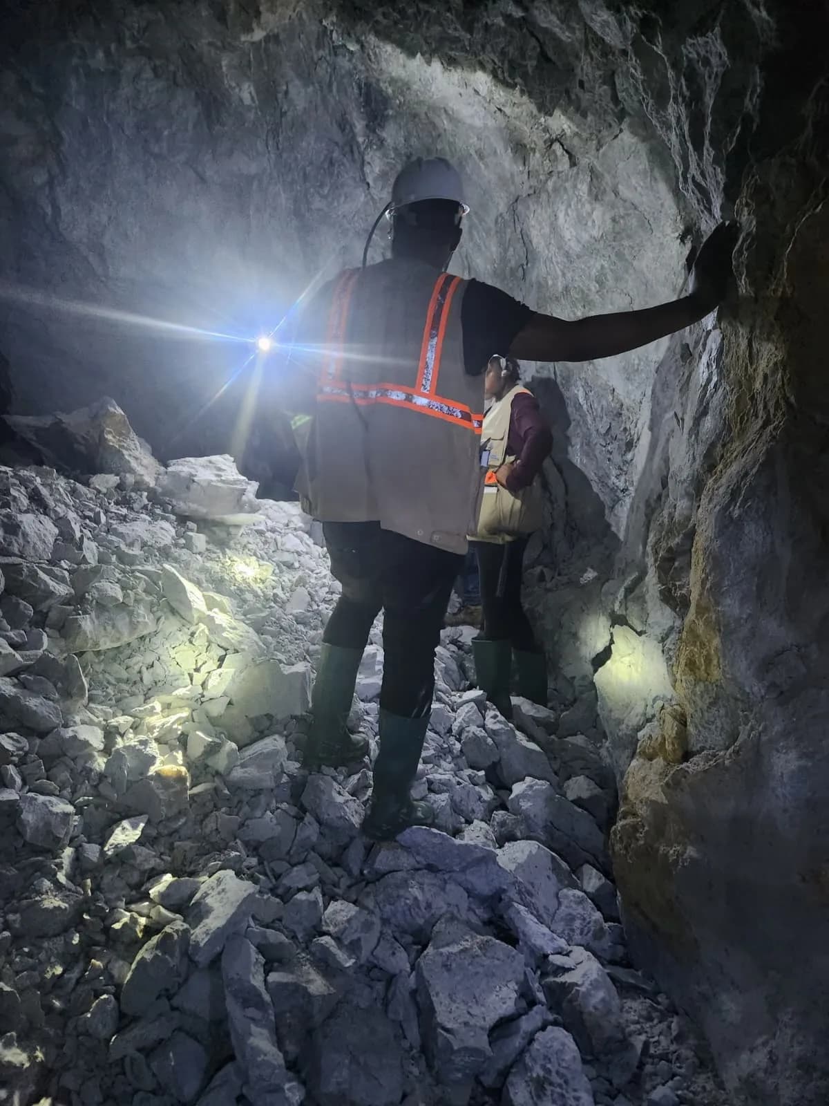 Geologist examining the tunnel wall by headlamp light