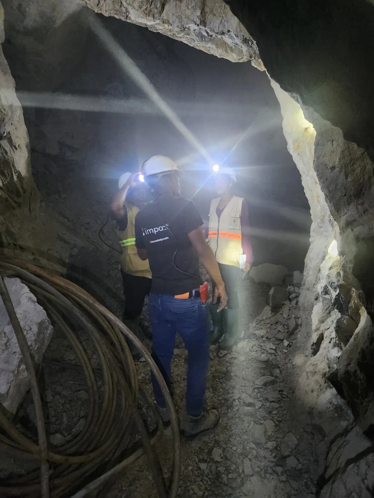 Geologists examining coiled cable inside the underground tunnel