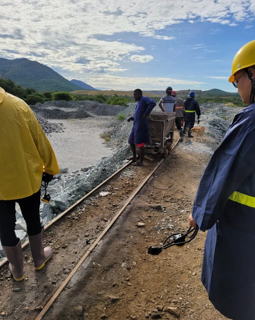Workers moving an ore cart along the rail track